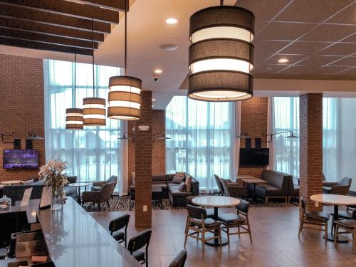 a lobby with tables and chairs and large windows at Hyatt Place Houston- Northwest/Cy-Fair in Houston