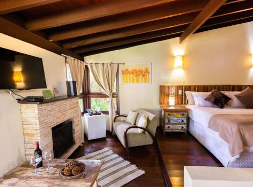 a bedroom with a bed and a fireplace at Pousada Jardim das Montanhas in Monte Verde