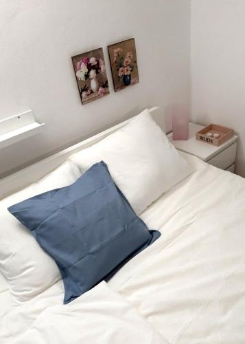 a blue pillow sitting on top of a white bed at Studio Una, 150m from the sea, parking, Crikvenica, Dramalj in Dramalj