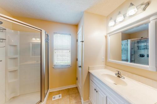 a bathroom with a sink and a shower and a mirror at Twin Lake Lookout in Panama City Beach