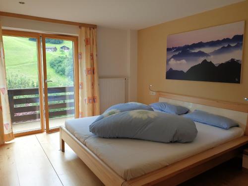 バルトロメベルクにあるHaus Bargaraの窓付きの部屋で、ベッド1台(青い枕付)