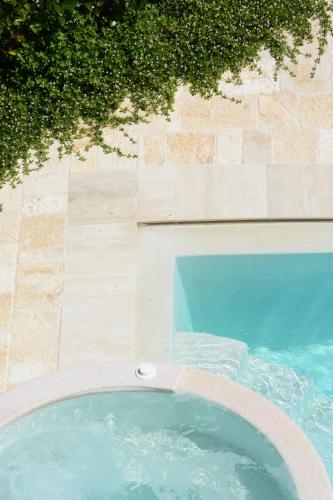 a swimming pool in front of a building with a blue pool at Casina Colosso - relais&more - in Nardò