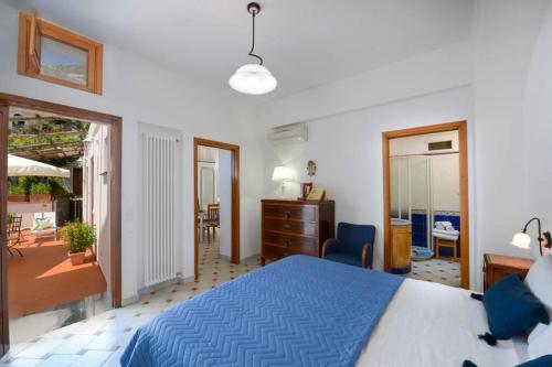 a bedroom with a blue bed and a balcony at Casa La Verbena in Praiano