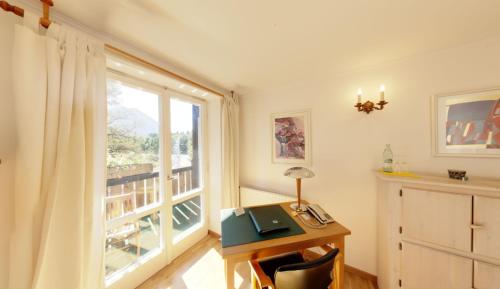 a room with a desk with a window and a desk at Outdoorhotel Jäger Von Fall in Lenggries