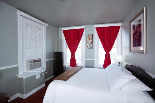 a bedroom with a white bed with red curtains at The Rialto Hotel in Laredo