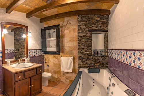 a bathroom with a tub and a toilet and a sink at Alojamientos Rurales Los Macabes in Alpujarra de la Sierra