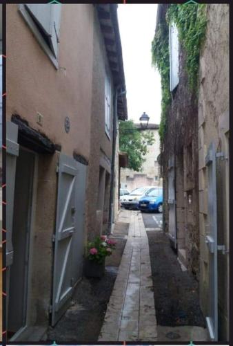a narrow alley with buildings and flowers on the side at Gîte de Claire in Lectoure