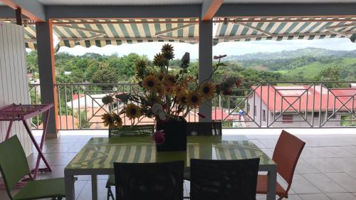 a table with a vase of flowers on a balcony at Domaine De Titine in Bonneville