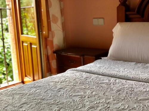 a bedroom with a bed next to a window at Hostal Posada La Panadera in Sepúlveda