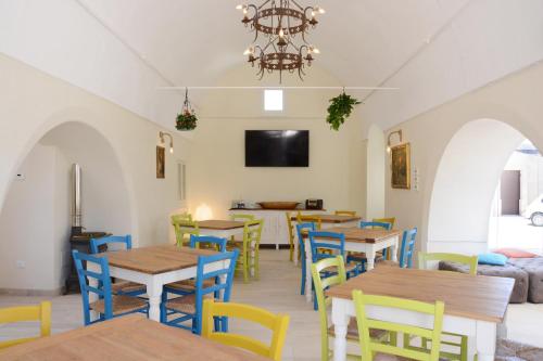 a restaurant with tables and chairs and a chandelier at Casina Colosso - relais&more - in Nardò