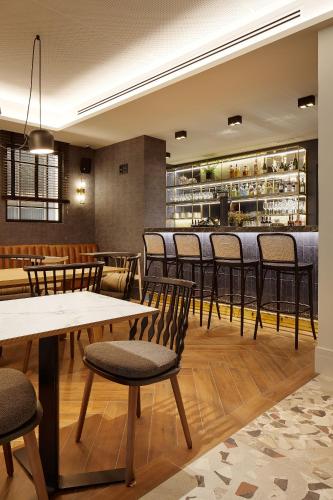 a restaurant with tables and chairs and a bar at Hotel SANSEbay in Donostia-San Sebastián