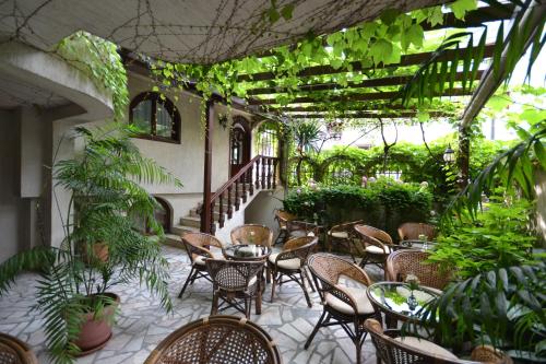 Family Hotel More في سوزوبول: فناء في الهواء الطلق مع الكراسي والطاولات والنباتات