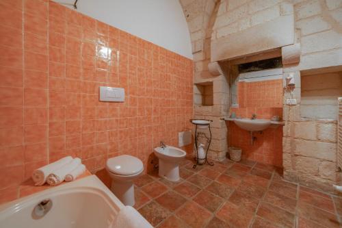 y baño con bañera, aseo y lavamanos. en Agriturismo Masseria del Bosco Makyva, en Borgagne