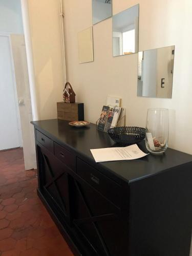 - une commode noire dans une pièce avec un miroir dans l'établissement Charming Apartment in the Heart of Ajaccio, à Ajaccio