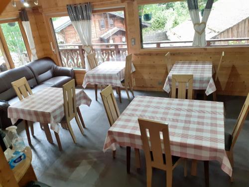 モルジヌにあるchalet le plan du rtiaのテーブル2台と椅子1脚とソファ1台付きのレストラン