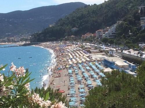 a crowded beach with umbrellas and crowds of people at GUEST HOUSE BERZEFI in Bergeggi