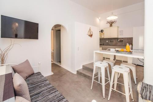 a living room with a couch and a kitchen at Avissalou Apartments in Agios Romanos