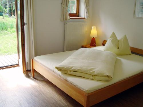 a bed with white sheets and pillows in a bedroom at Outdoorhotel Jäger Von Fall in Lenggries