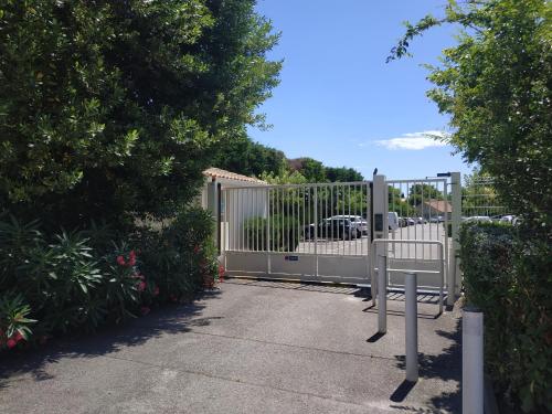 a gate in a driveway with a fence at Appartement REZ DE JARDIN avec SPA entre la MER et Montpellier 10mn in Lattes