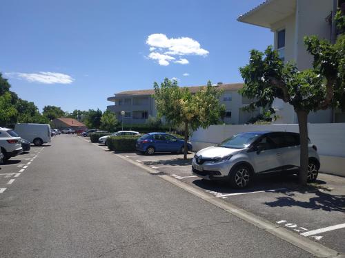 a car parked in a parking lot next to a building at Appartement REZ DE JARDIN avec SPA entre la MER et Montpellier 10mn in Lattes