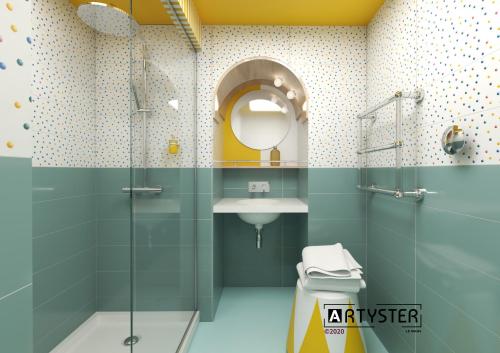 uma casa de banho com um chuveiro, um lavatório e um espelho. em Artyster Le Mans em Le Mans