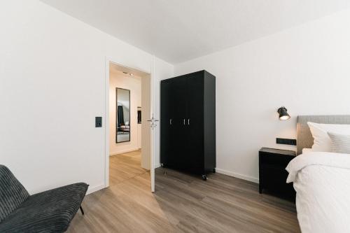 a bedroom with a black cabinet next to a bed at Moderne 3 Zi-FeWo "Industrial Style" 70 qm Naehe Freiburg in Simonswald