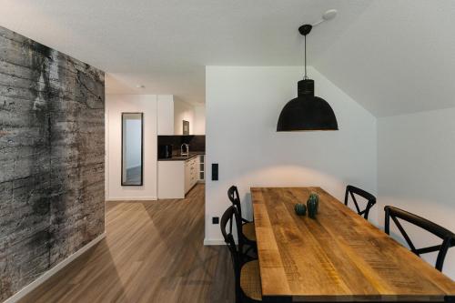 een eetkamer en een woonkamer met een houten tafel bij Moderne 3 Zi-FeWo "Industrial Style" 70 qm Naehe Freiburg in Simonswald