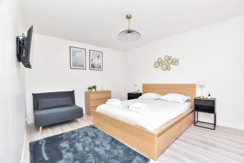 a bedroom with a bed and a chair at CMG Philharmonie de Paris/ Jaures in Paris