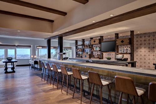 a bar in a restaurant with chairs and a counter at Chaminade Resort & Spa in Santa Cruz