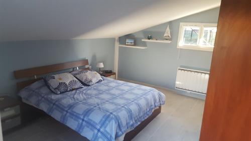 1 dormitorio con 1 cama con edredón azul y blanco en bulle de bonheur, en Gujan-Mestras
