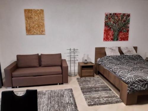 a living room with a bed and a couch at Mira apartman Queen lakosztály in Debrecen