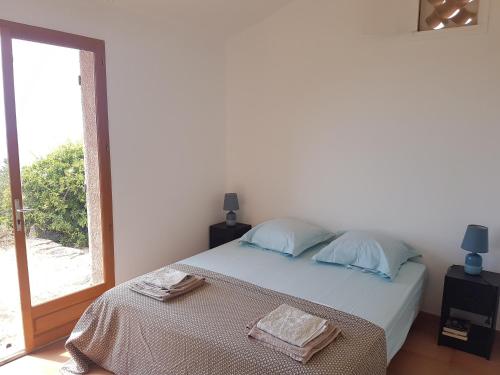 une chambre avec un lit avec deux serviettes dessus dans l'établissement Maison sur Palombaggia, à Porto-Vecchio