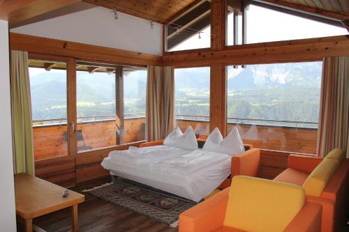 Ski In/Ski Out Ferienhaus Berghof by Schladmingurlaub في سخلادميخ: غرفة نوم مع سرير في غرفة مع نوافذ