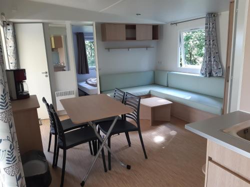 Cette petite chambre comprend une table, des chaises et un canapé. dans l'établissement Relais du Haget, à Cravencères