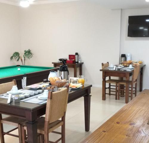a dining room with a table and a pool table at Casa Colina do Sol in Nova Petrópolis