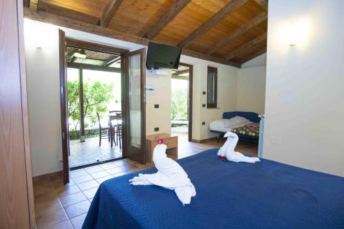 two swans are sitting on a bed in a room at Family Resort Cala di Luna in Marina di Camerota
