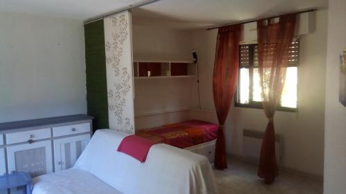 Habitación pequeña con cama y ventana en Studio de 27 m² + 70 m² de jardin à 100 m des plages, en Cavalaire-sur-Mer