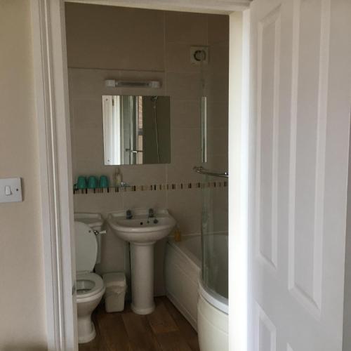 a bathroom with a sink and a toilet and a mirror at Old Church House in Newport