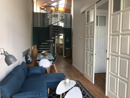 a living room with a blue couch and a staircase at Friesischer Hof, Ferienwohnungen mit Indoor Spielplatz, kostenfreien Parkplatz und W-Lan in Hage