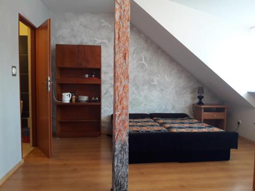 コウォブジェクにあるPokoje Gościnne Perłowaのベッドルーム1室(ベッド1台付)、階段