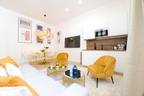 un salon avec un canapé et des chaises et une cuisine dans l'établissement Luxury home in PARIS - Musée du Louvre, à Paris