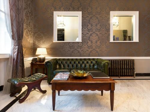 a living room with a green couch and a table at Staunton Hotel - B&B in London