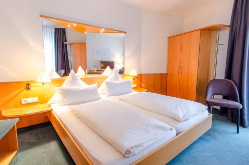 een slaapkamer met een groot bed, een bureau en een stoel bij Hotel Gasthof Hecht in Wolfach