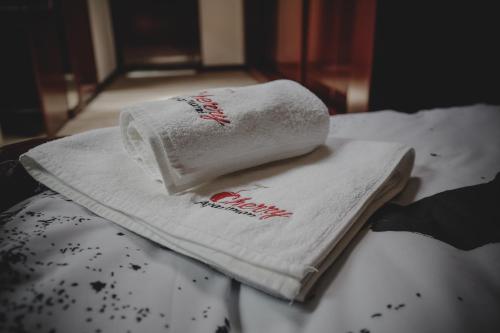 a stack of towels sitting on top of a bed at Cherry apartmani in Gornji Milanovac