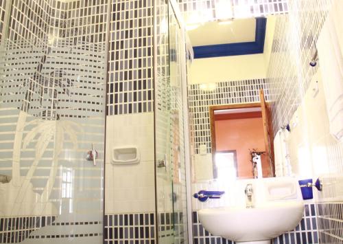 a bathroom with a sink and a shower at Patio de Piedra Hotel Boutique in La Paz