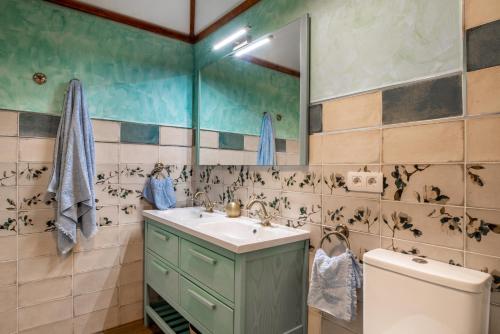 y baño con lavabo, espejo y aseo. en Villa La Perla, en Candelaria