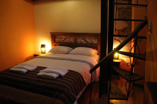 a bedroom with a bed with towels on it at Patio de Piedra Hotel Boutique in La Paz