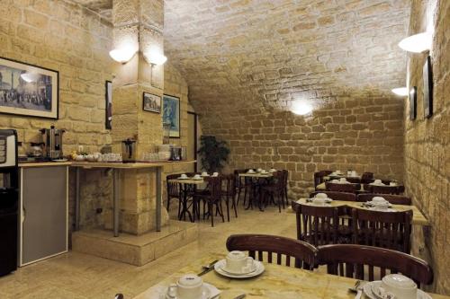 un restaurant avec des tables et des chaises dans une salle dans l'établissement Hotel Americain, à Paris