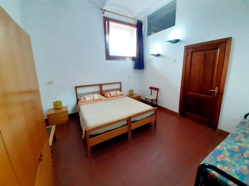 a small bedroom with a bed and a window at Villa Very in Marina di Campo