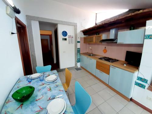 a kitchen with a table and a kitchen with blue chairs at Villa Very in Marina di Campo